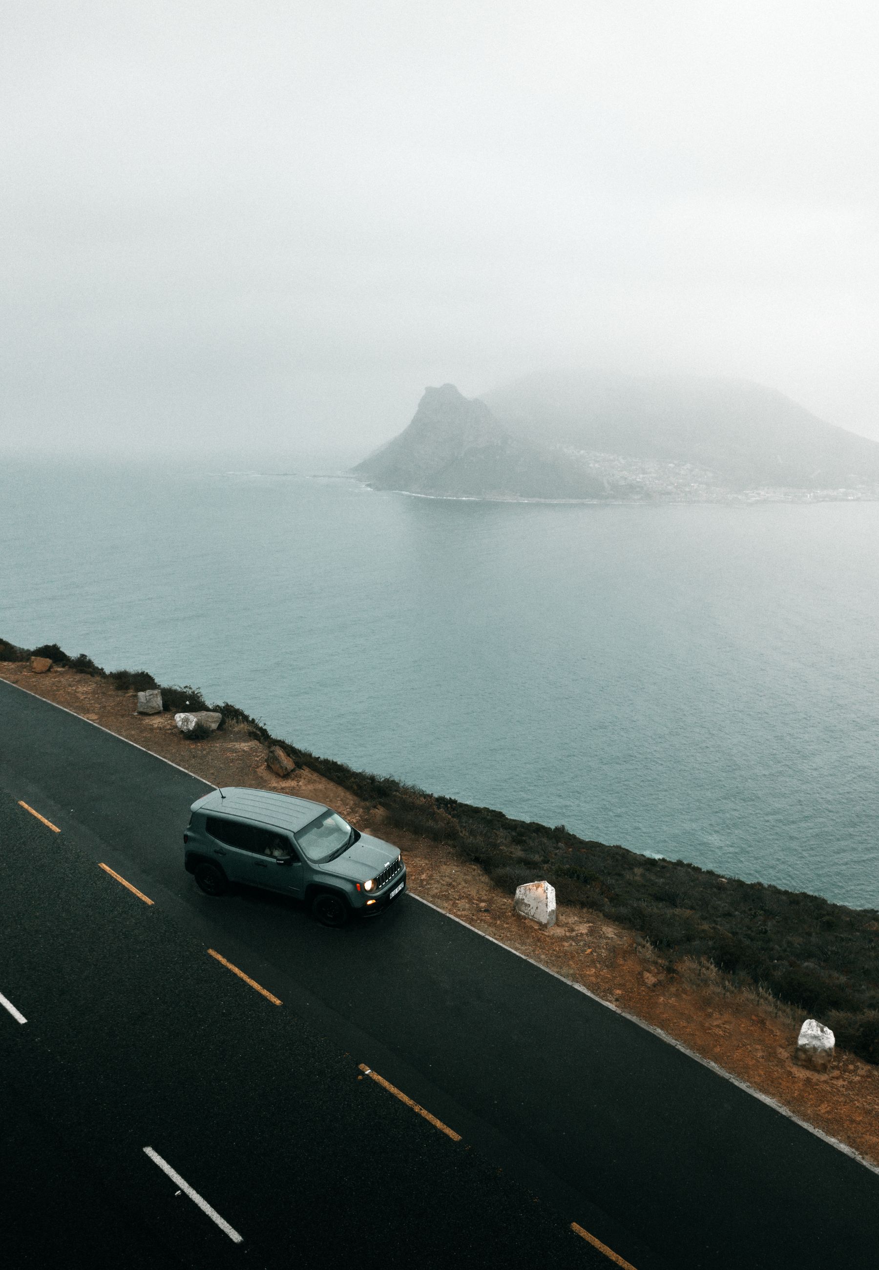 SUV travelling along a misty Cape Town coastal road