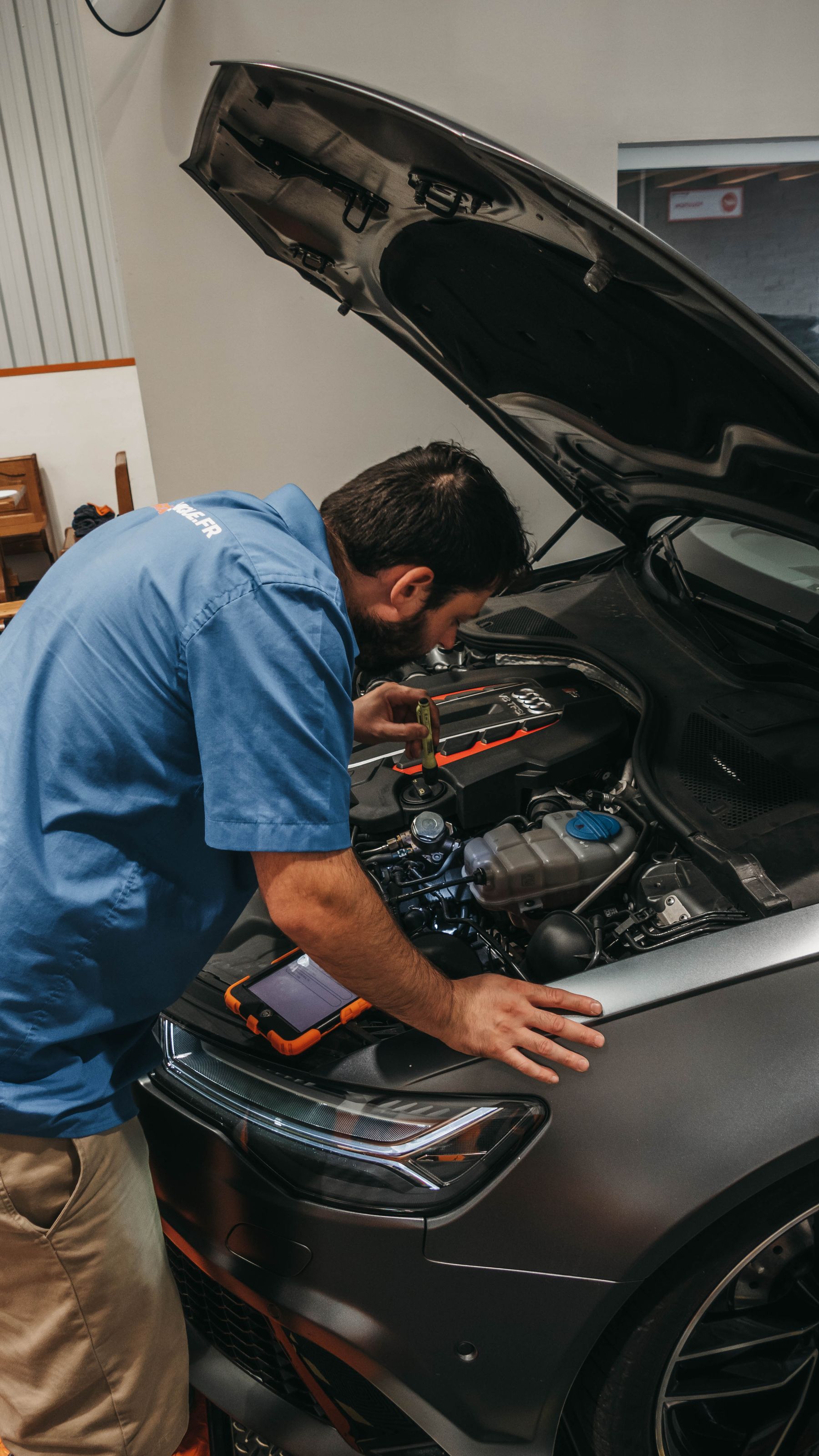 Technician inspecting a vehicle engine during a service